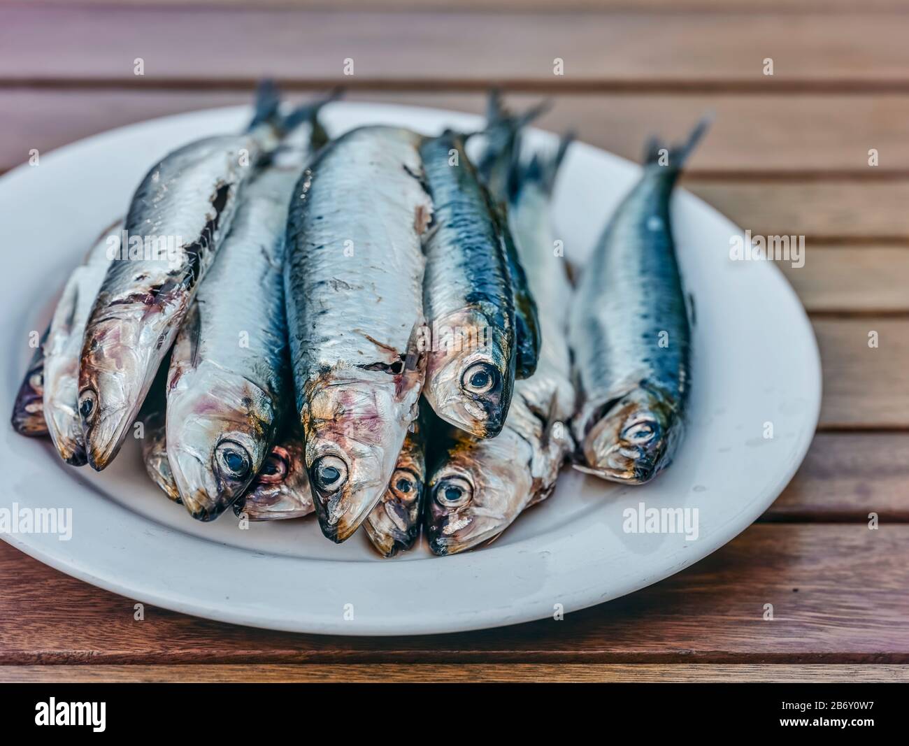 A plate of herrings and sardines ready on a Woden table ready for cooking  Stock Photo - Alamy
