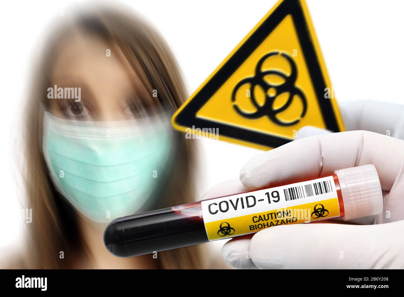 FOTOMONTAGE, Haende halten Blutentnahmeroehrchen und Biogefaehrdungsschild vor Frau mit Atemschutzmaske, Symbolfoto Coronavirus Stock Photo