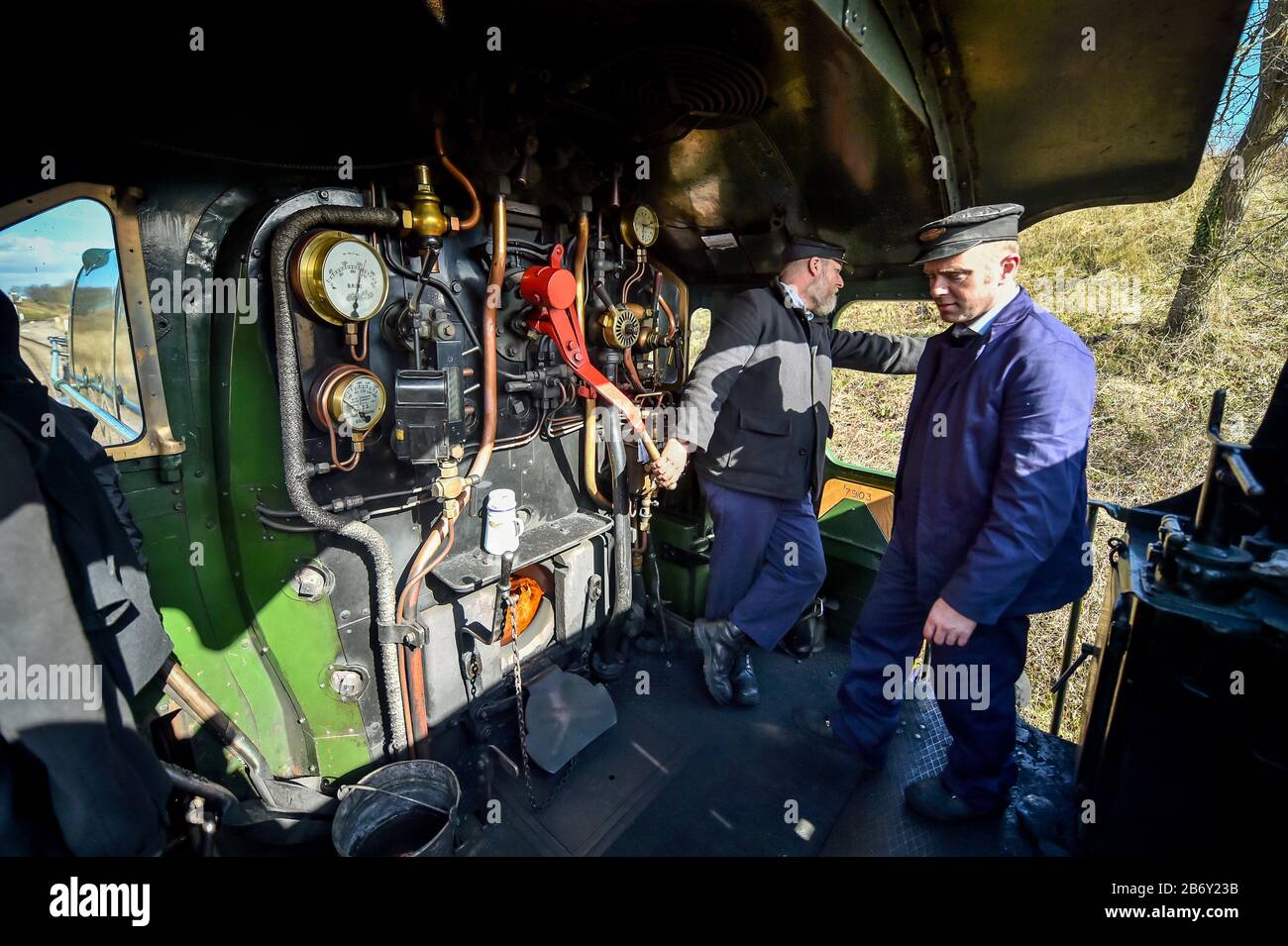 Footplate crew aboard the Great Western Railway Modifield Hall Class 7903 Foremarke Hall steam locomotive, built in 1949, which is transporting passengers from Toddington station to Cheltenham races during the festival. Stock Photo