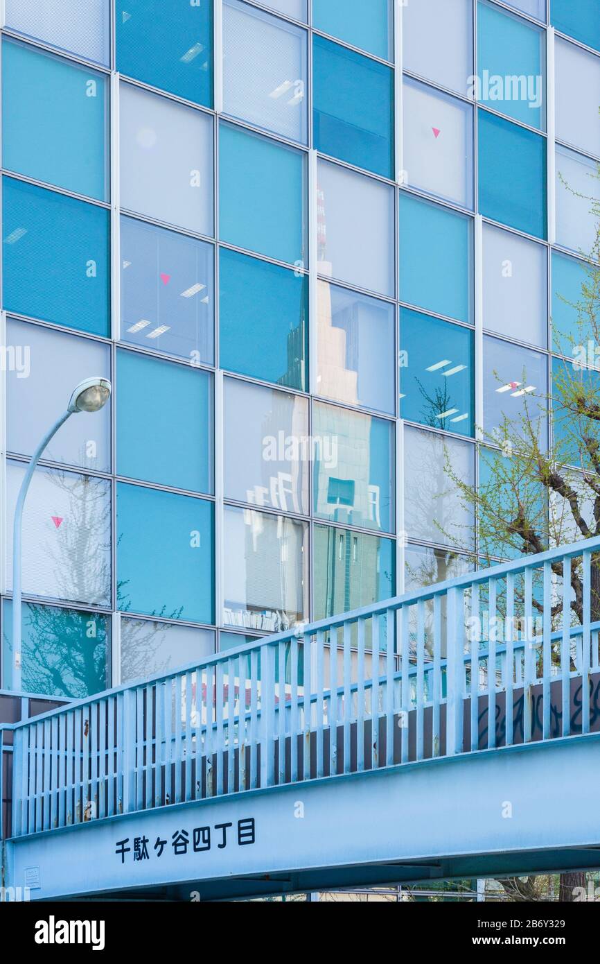 The NTT Docomo Yoyogi Building reflected in a blue and grey building in Shikjuku, Tokyo. Stock Photo