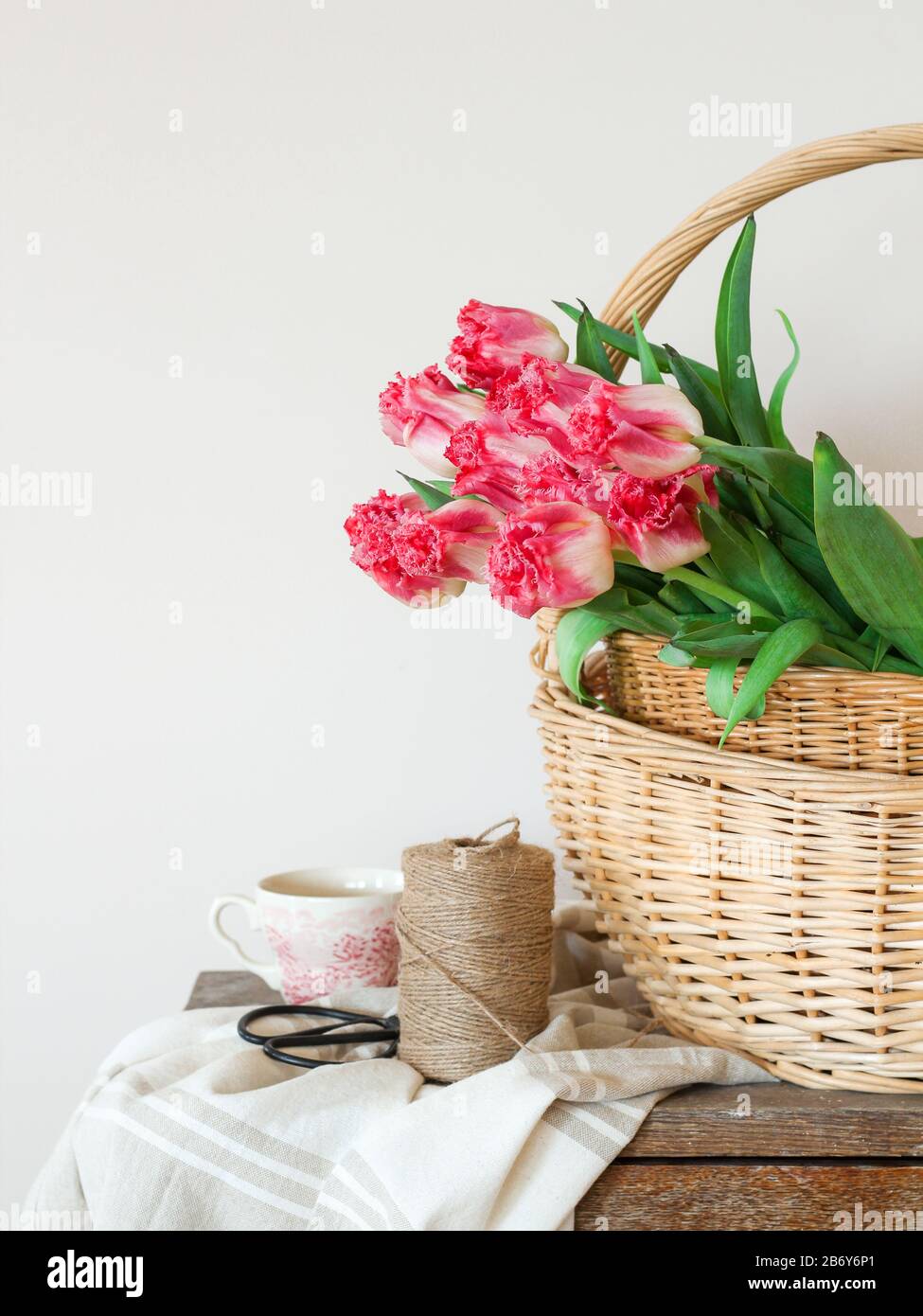 Spring composition with pink tulips in a basket Stock Photo