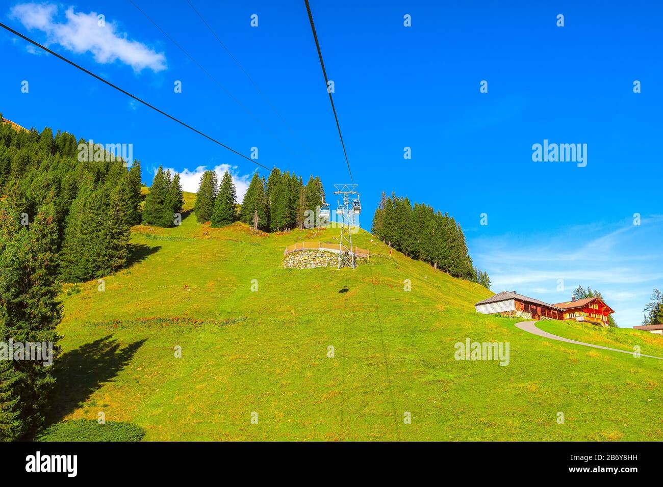 Grindelwald, Switzerland cable car cabins Jungfrau Top of Europe and green Swiss Alps mountains panorama landscape Stock Photo