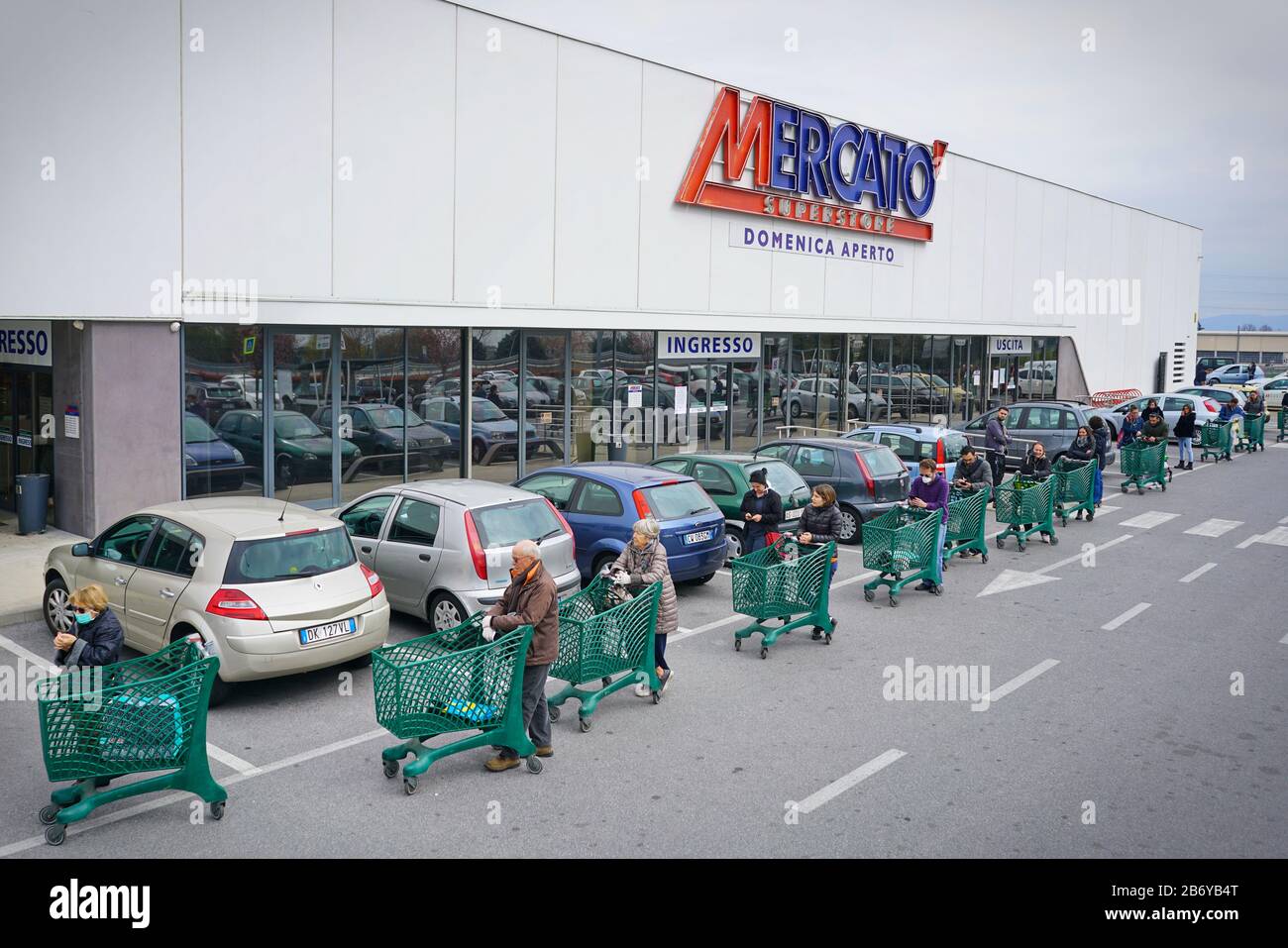 Coronavirus pandemic effects: long queue to enter the supermarket for grocery shopping. Milan, Italy - March 2020 Stock Photo