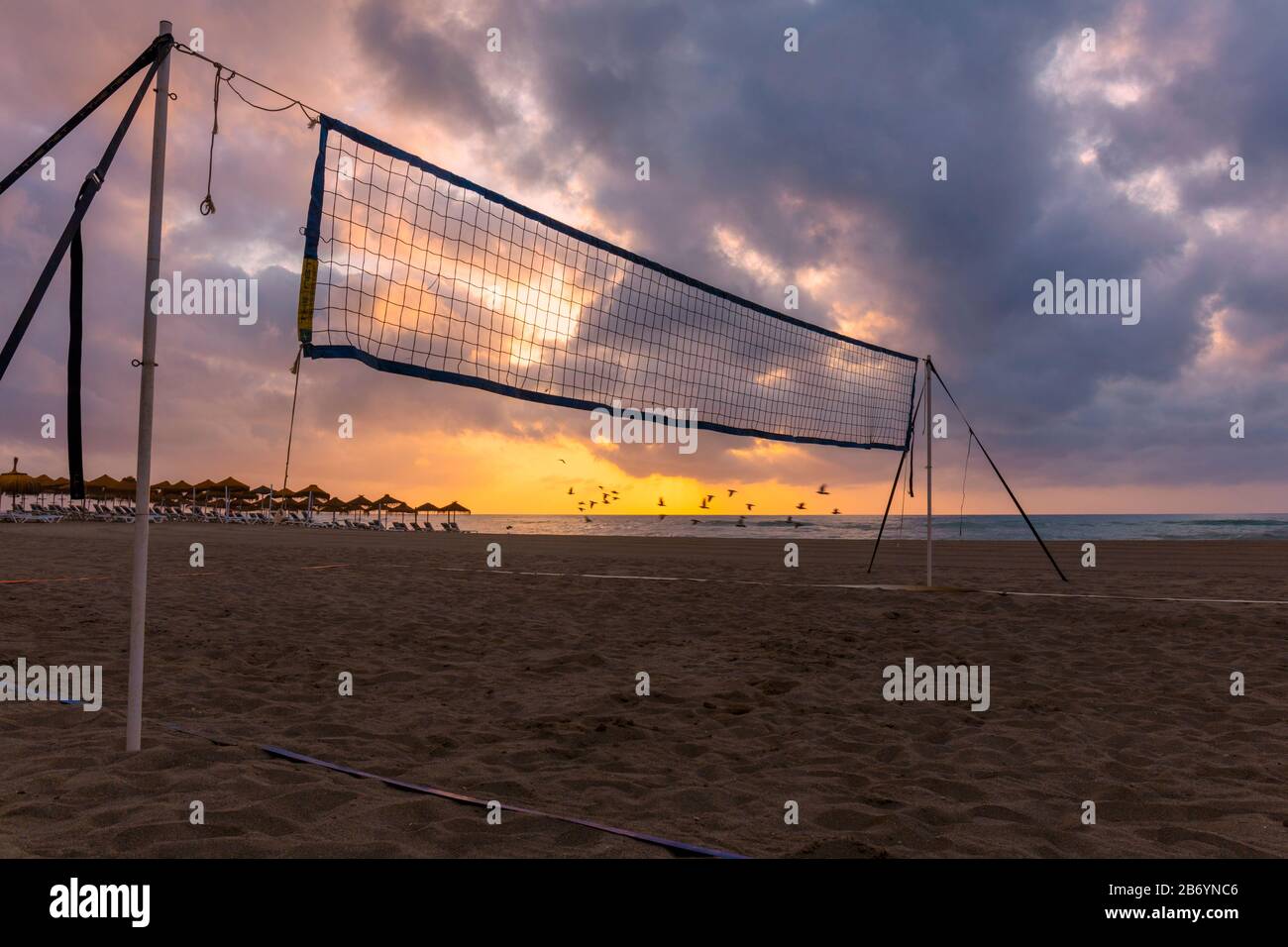 Beach volleyball net on beach at sunrise. Playamar beach, Torremolinos, Costa del Sol, Malaga