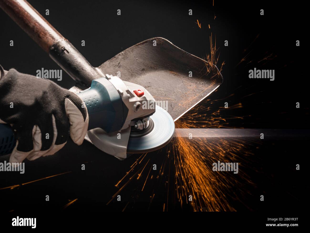 Sharpening garden shovel blade with electric angle grinder indoor Stock