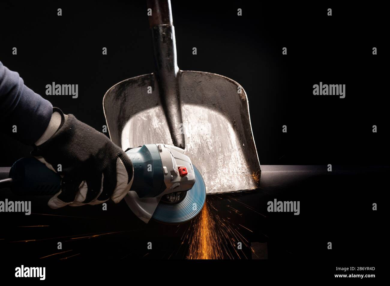 Sharpening garden shovel blade with electric angle grinder indoor Stock