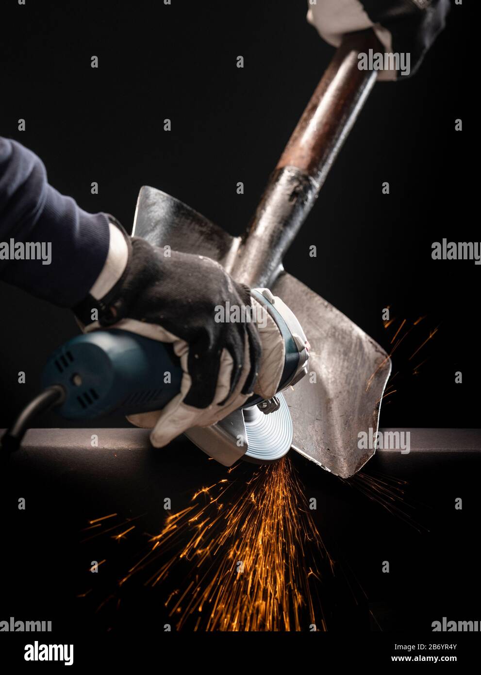 Sharpening garden shovel blade with electric angle grinder indoor Stock