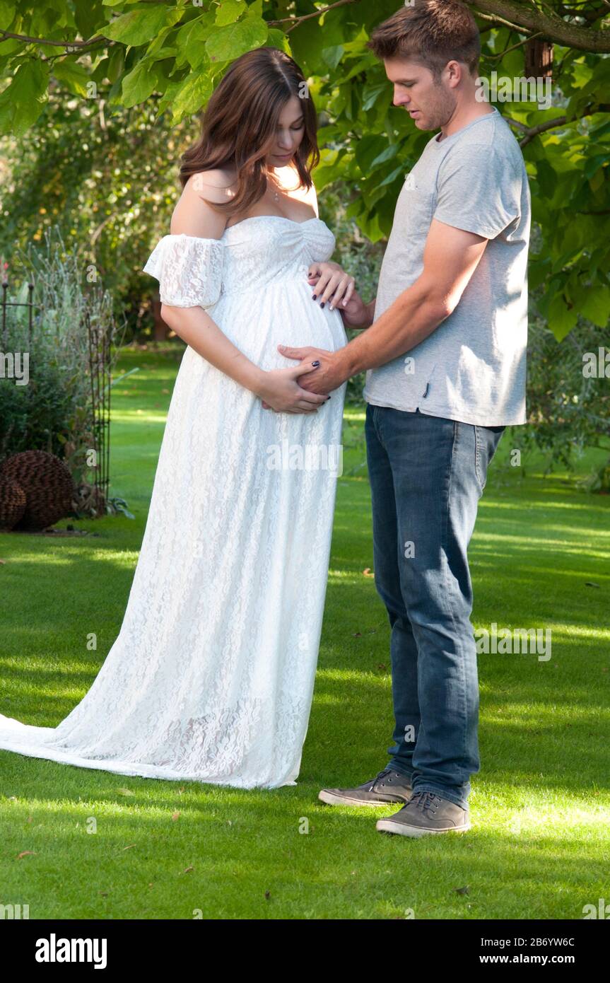 Beautiful pregnant young woman and her partner looking worried Stock Photo