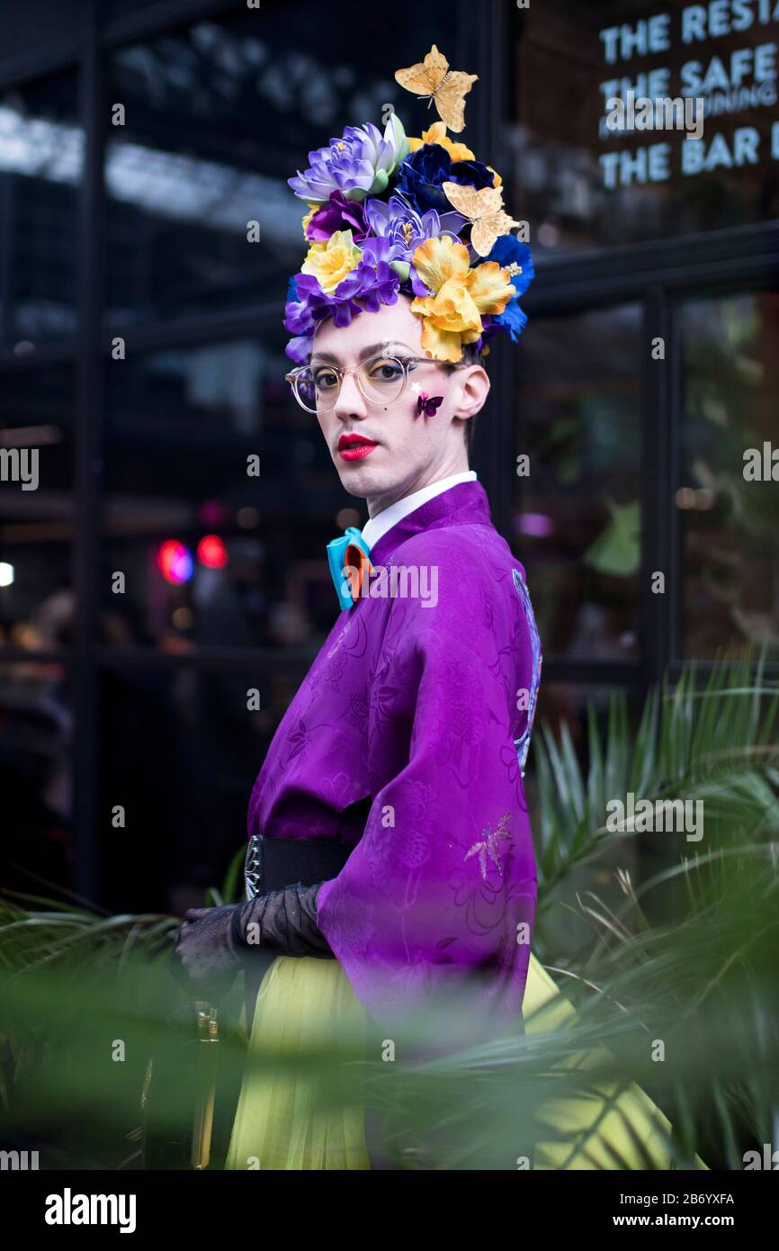 LONDON, UK- febryary 15 2020: Fashionable people on the street . Street style. A man in a purple kimono with a bright make-up and a crown made of yell Stock Photo