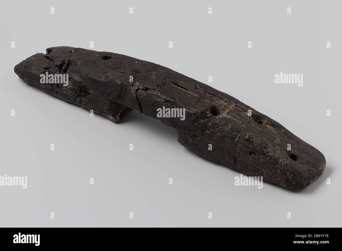 Clamp; eroded; straight timber, curved upper side, flat underneath, rectangular ends, with 3 circular holes, on underside rectangular central notch. Manufacturer : anoniemPlaats manufacture: Nederland Dating: 1700 - in of voor 13-jul-1743 Material: hout  Dimensions: h 28,6 cm.  × b 4,8 cm.  × d 4,5 cm.  Date: 1743 - 1743 Stock Photo