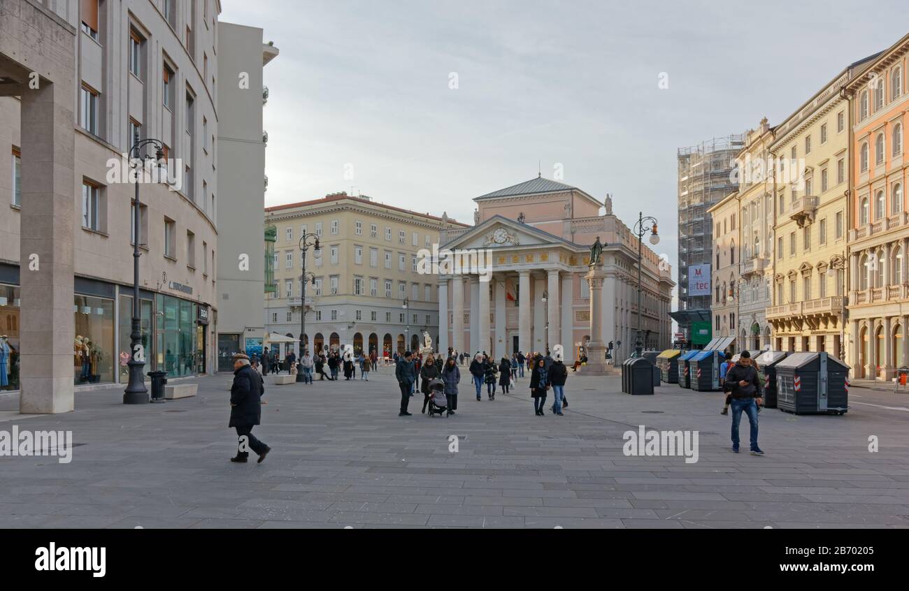 TRIESTE, Italy - February 16, 2020: City life in Borsa square in a late winter afternoon, with the neoclassic palace home of the Chamber of Commerce Stock Photo