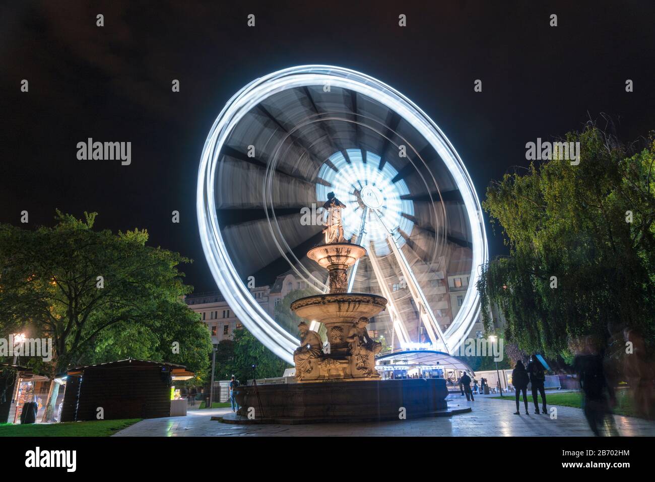 Danubius Fountain at night with Budapest Eye, ferris wheel at night Stock Photo