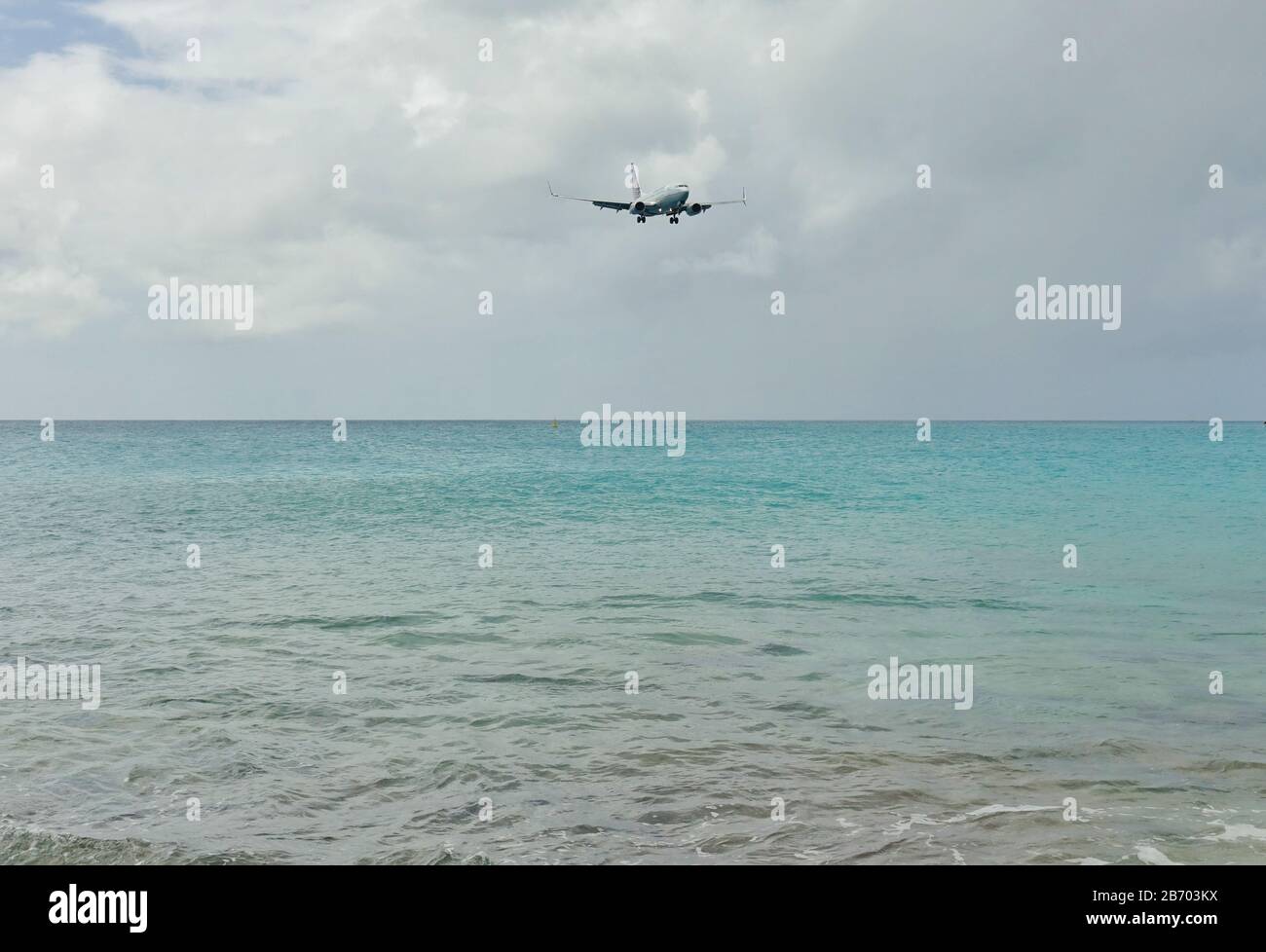 SAINT MARTIN, DUTCH ANTILLES -8 FEB 2020- An airplane from United Airlines (UA) landing over water at Maho Beach at the Princess Juliana International Stock Photo