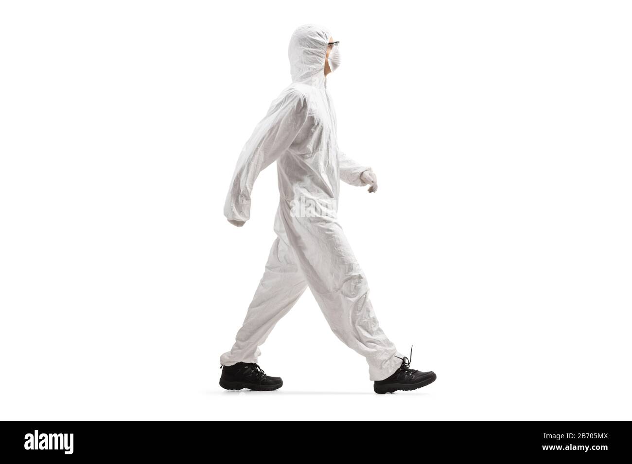 Full length profile shot of a man wearing a protective suit and mask and walking isolated on white background Stock Photo