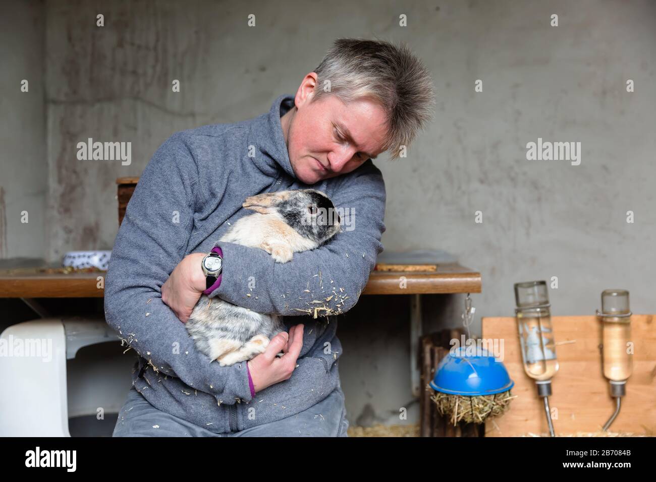 mature woman holding a pet rabbit in the arms Stock Photo
