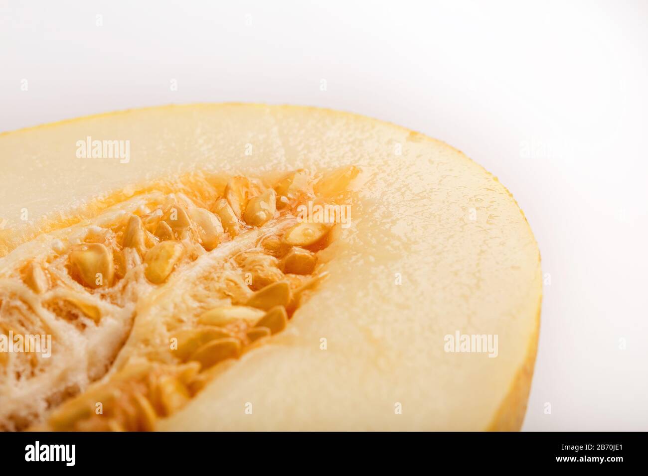 Yellow torpedo melon on a white background, divided into slices and