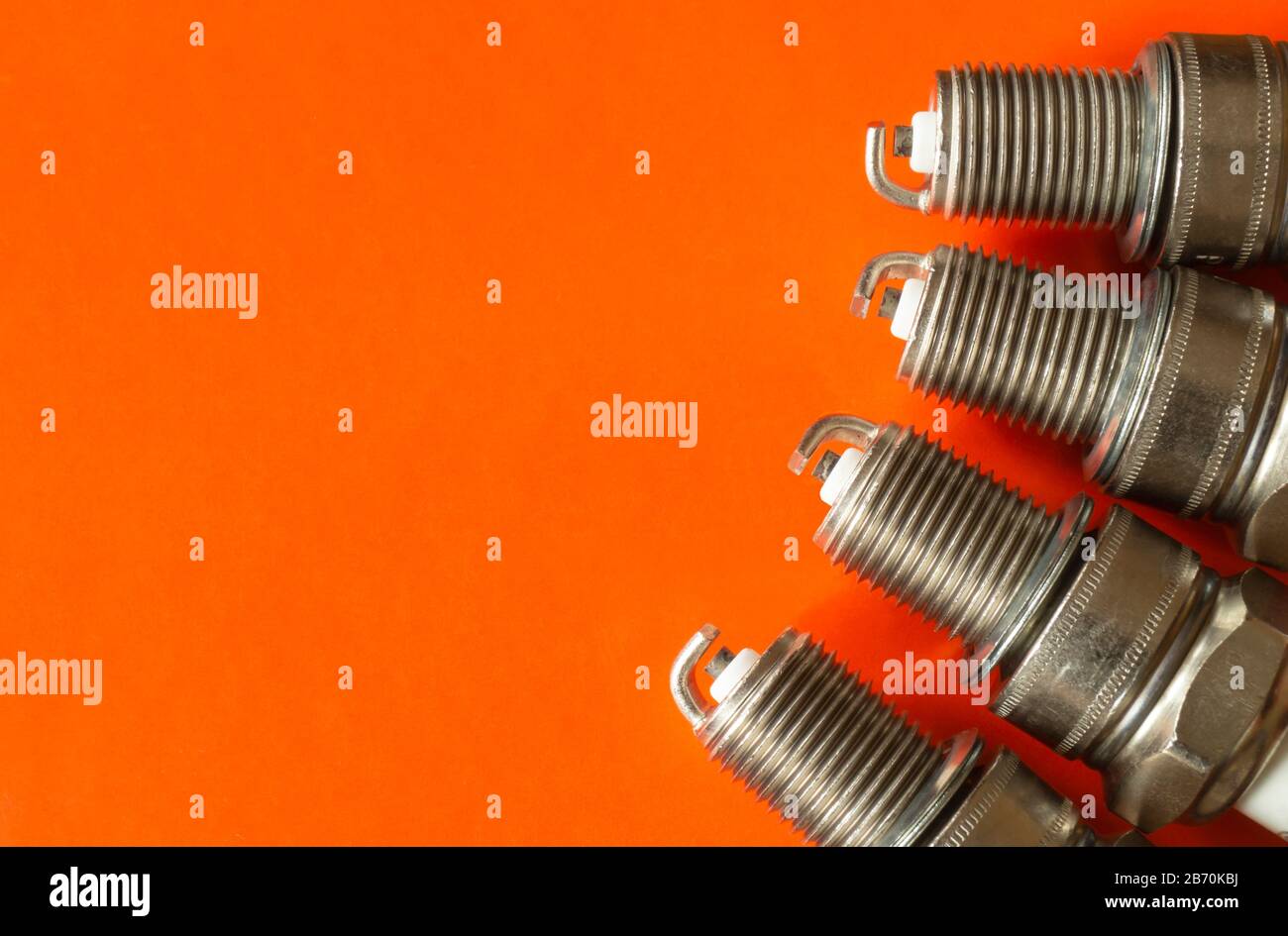 The Car spark plug on orange background. Electric device for machine