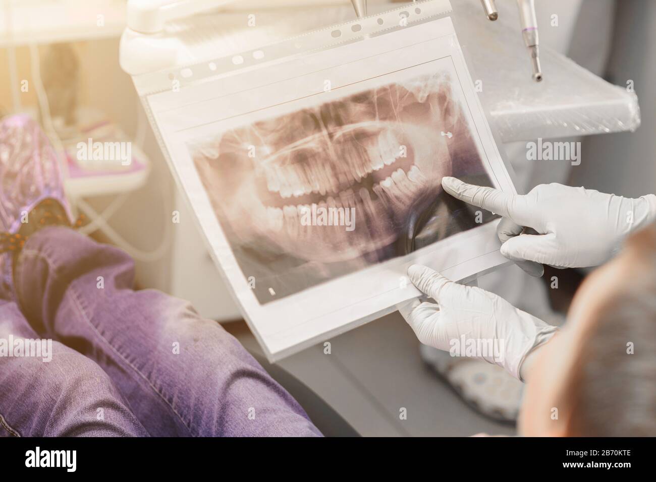 An orthodontist doctor shows the boy an xray of his teeth.2020 Stock