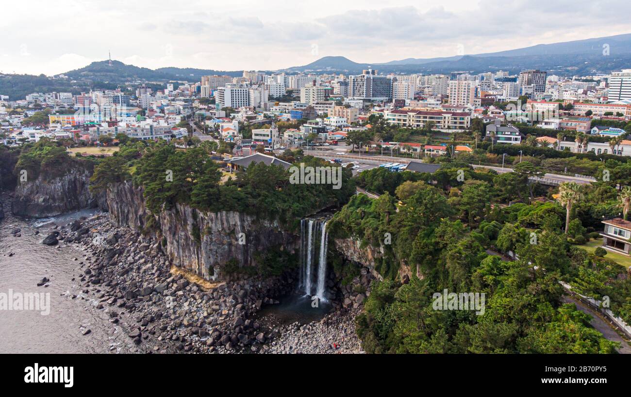 Aerial View of The High Waterfall Jeongbang, Lagoon and Seoqwipo on Jeju Island, South Korea. Stock Photo