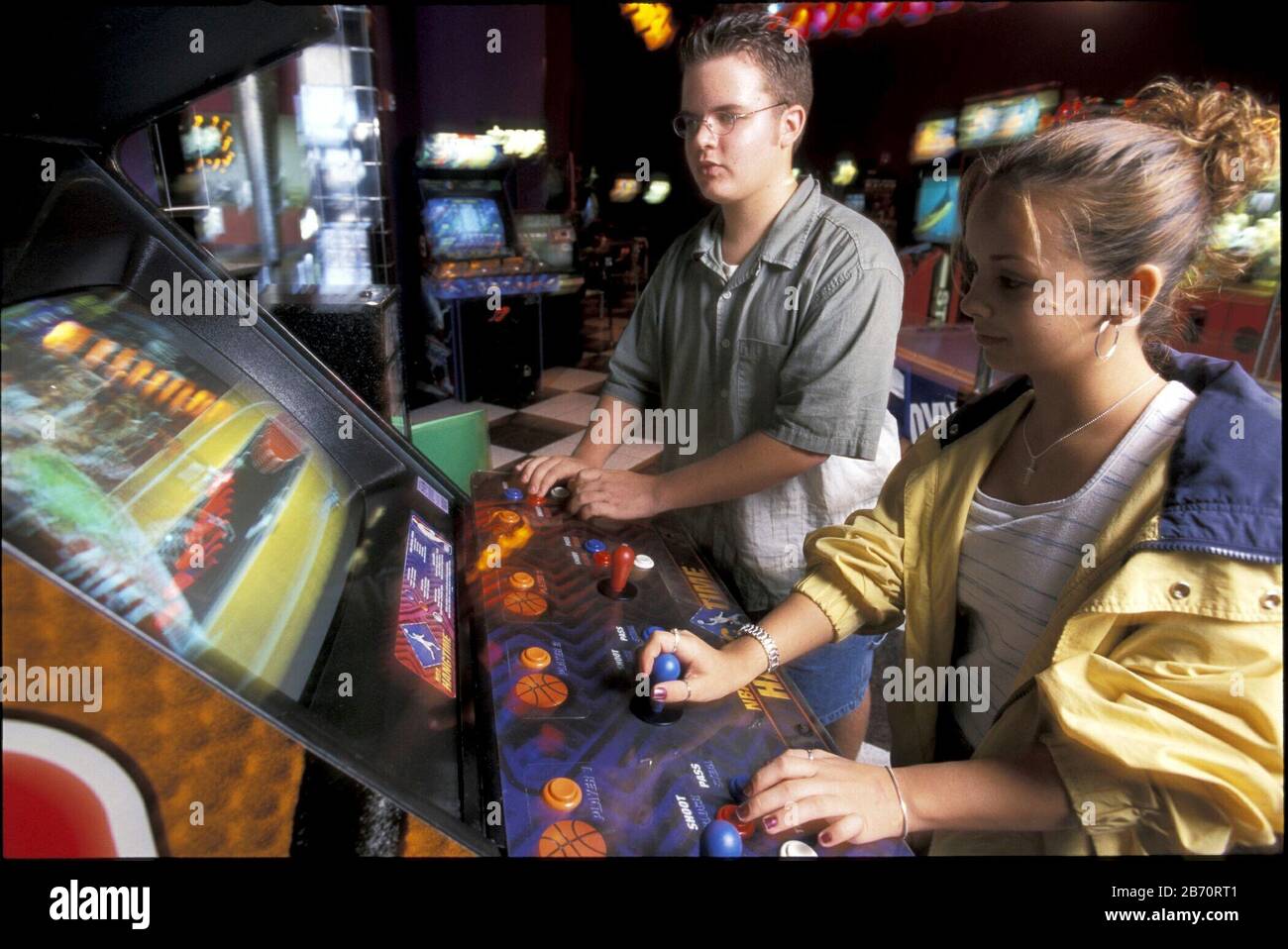 Austin Texas USA Middle school friends play video game at arcade. MR