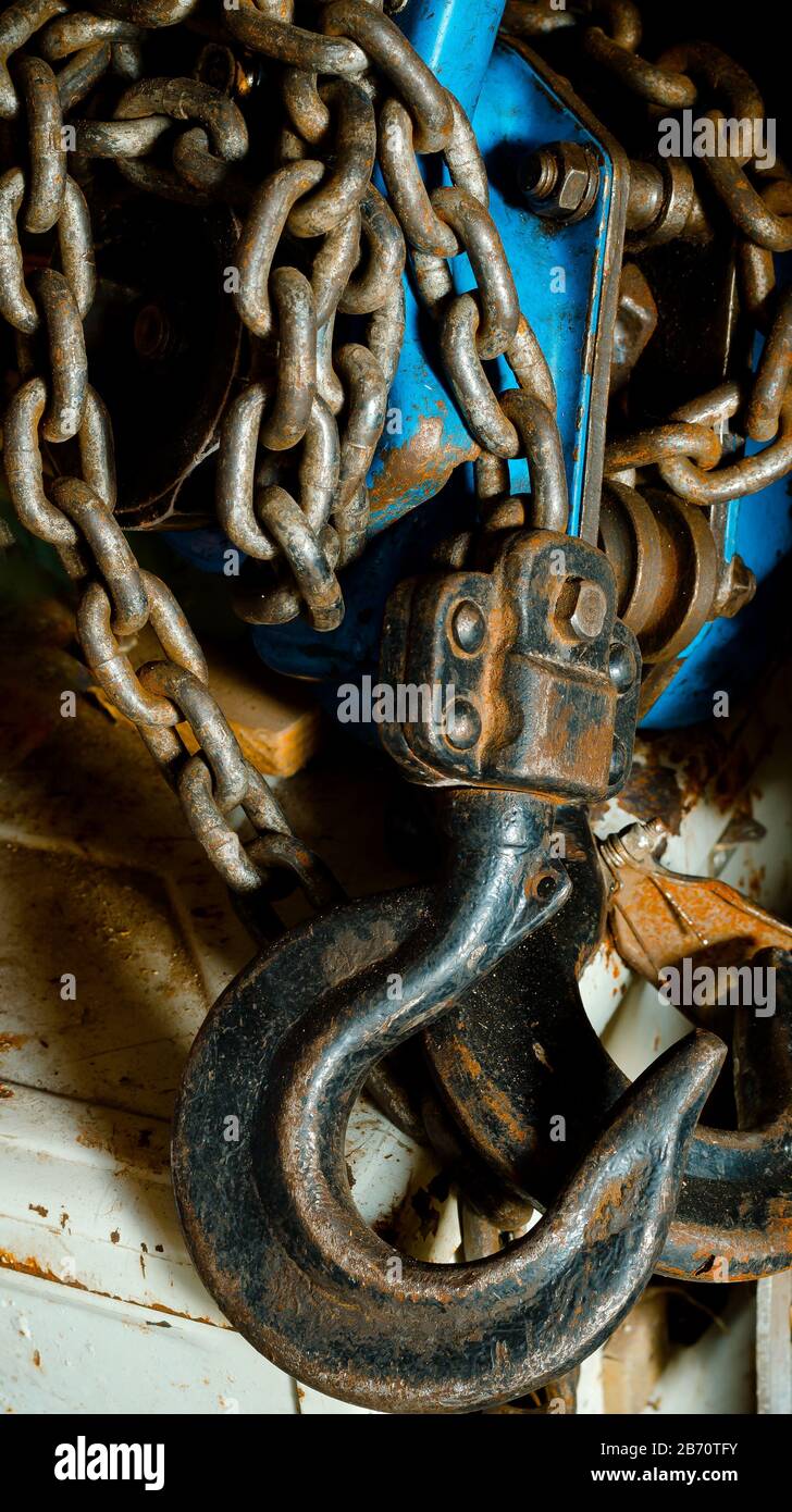 Used manual hoist closeup. A rusty hand tool lies on a workbench