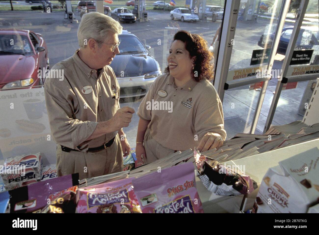 Austin, Texas USA, 2004:  ExxonMobil convenience store clerk (right) talks to store manager.  ©Bob Daemmrich Stock Photo