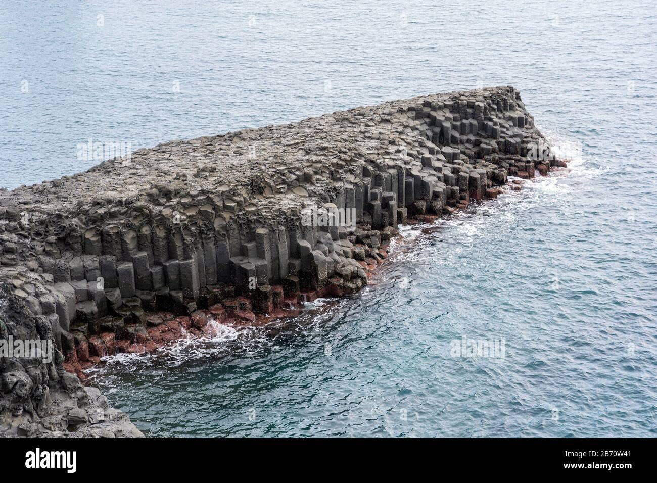 Basaltic Volcanic Columnar Joints Coast and Blue Water in JungMun in Jeju Island, South Korea. Stock Photo