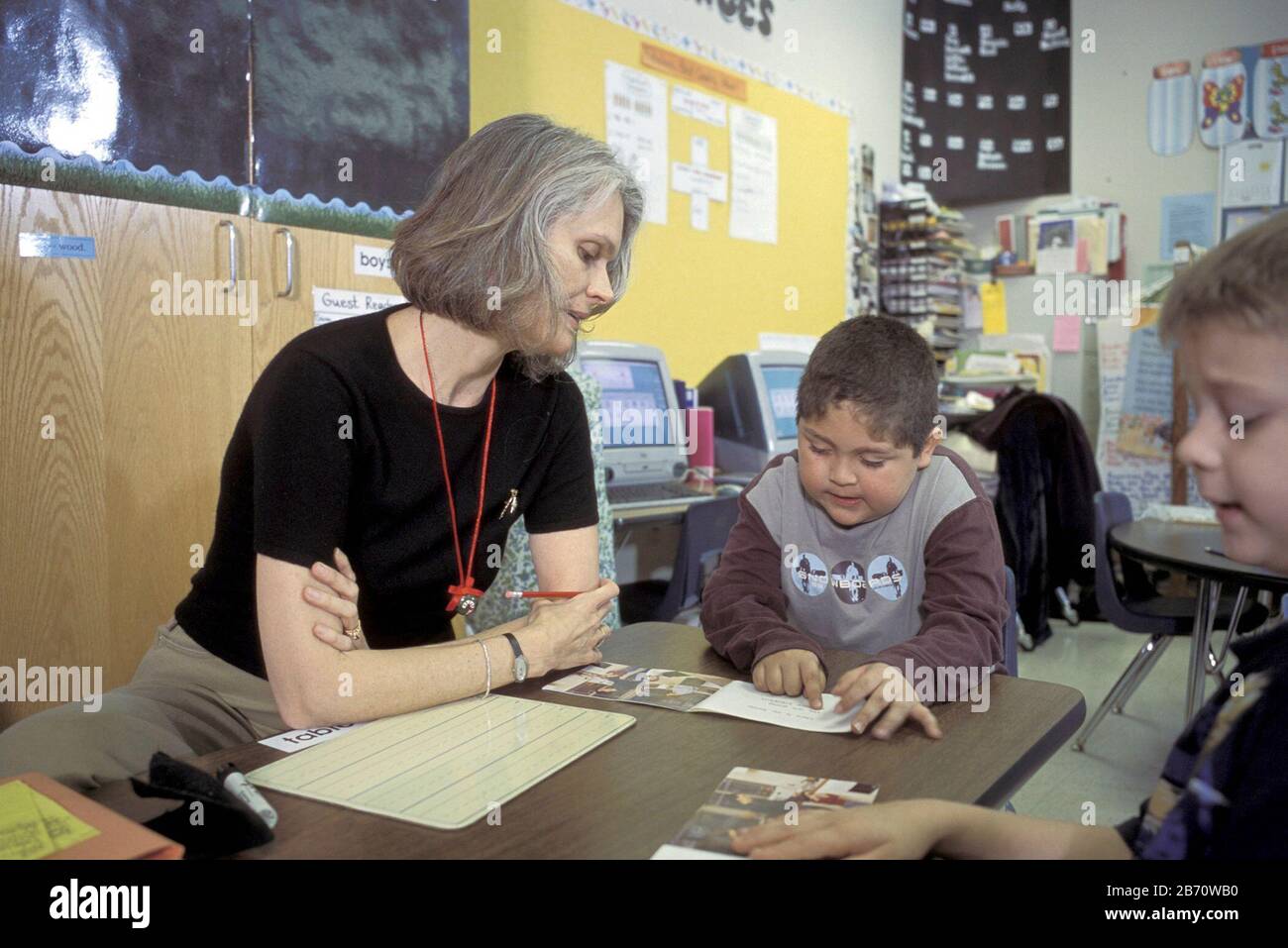 Austin, Texas USA, 2003: First grade student points to vocabulary word as teacher looks on during phonics lesson in classroom at Metz Elementary School. MR ©Bob Daemmrich Stock Photo