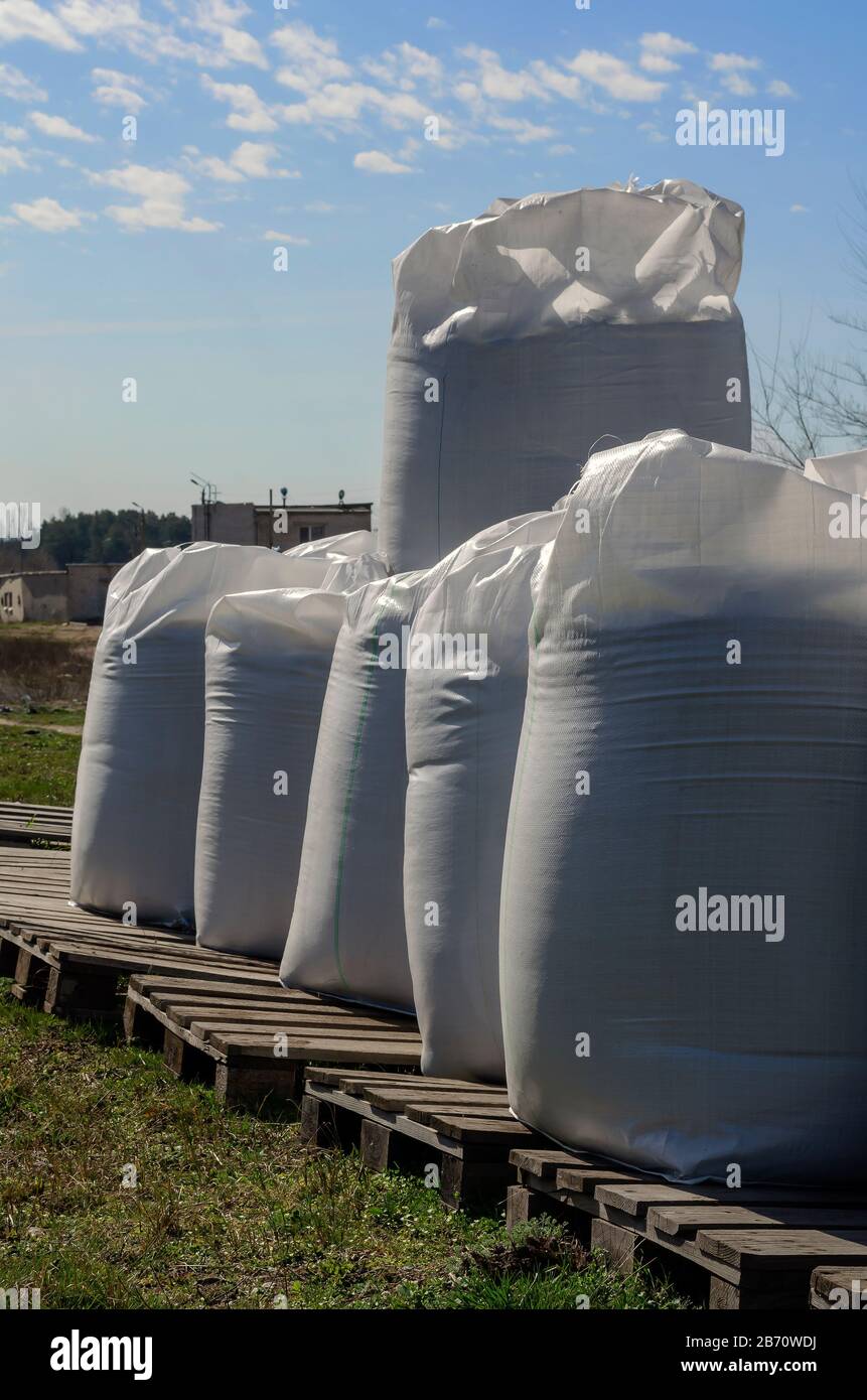 Agricultural fertilizers in big bags. Full white big bags on wooden