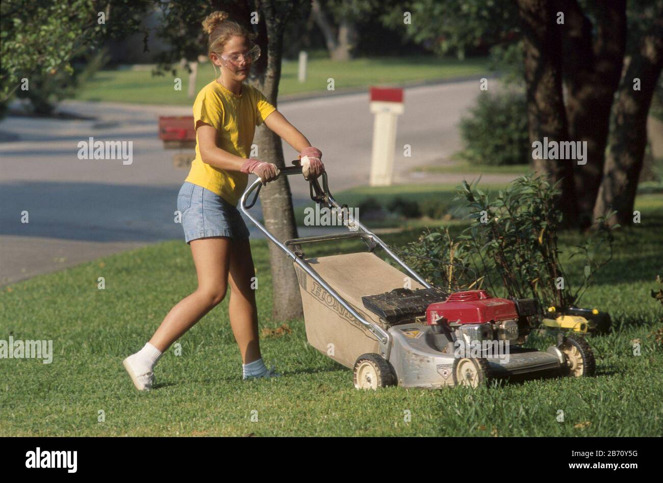 Austin, Texas USA: 15-year-old girl mowing lawn. MR ©Bob Daemmrich/ Stock Photo