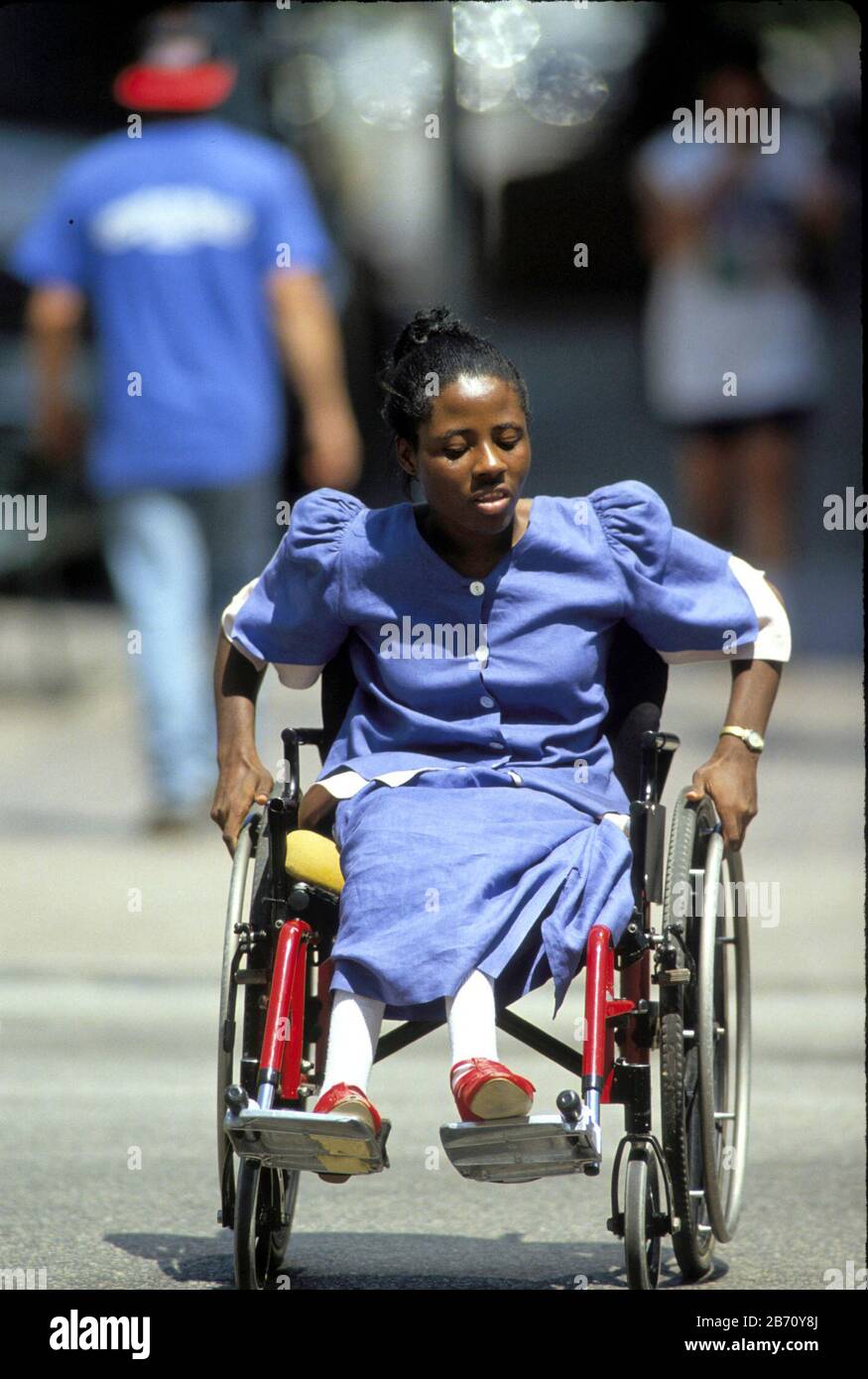 Austin Texas USA: Black woman maneuvering wheelchair on downtown sidewalk..  MR  ©Bob Daemmrich Stock Photo
