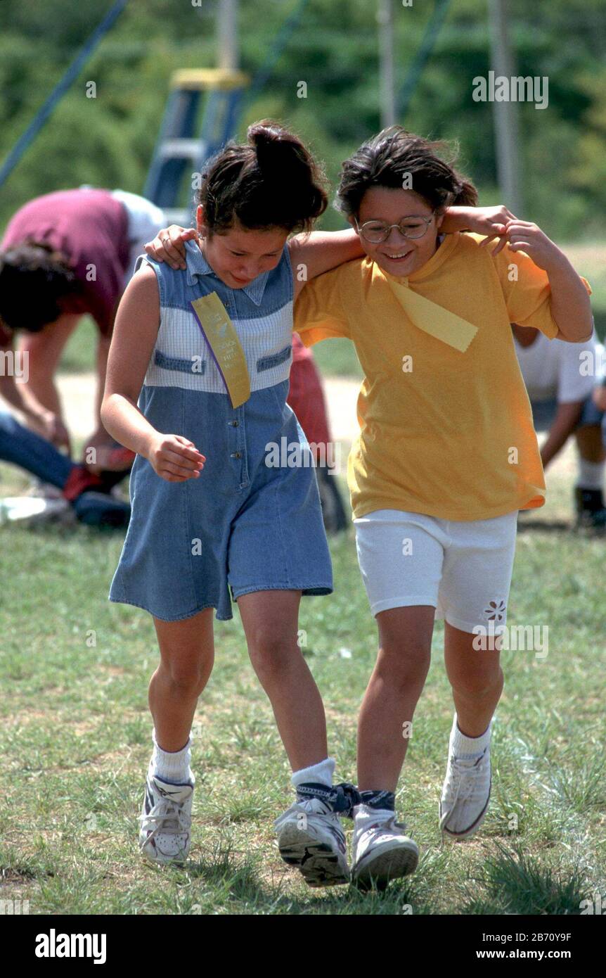 Austin, Texas USA; Fourth-grade girls competing in three-legged race at ...