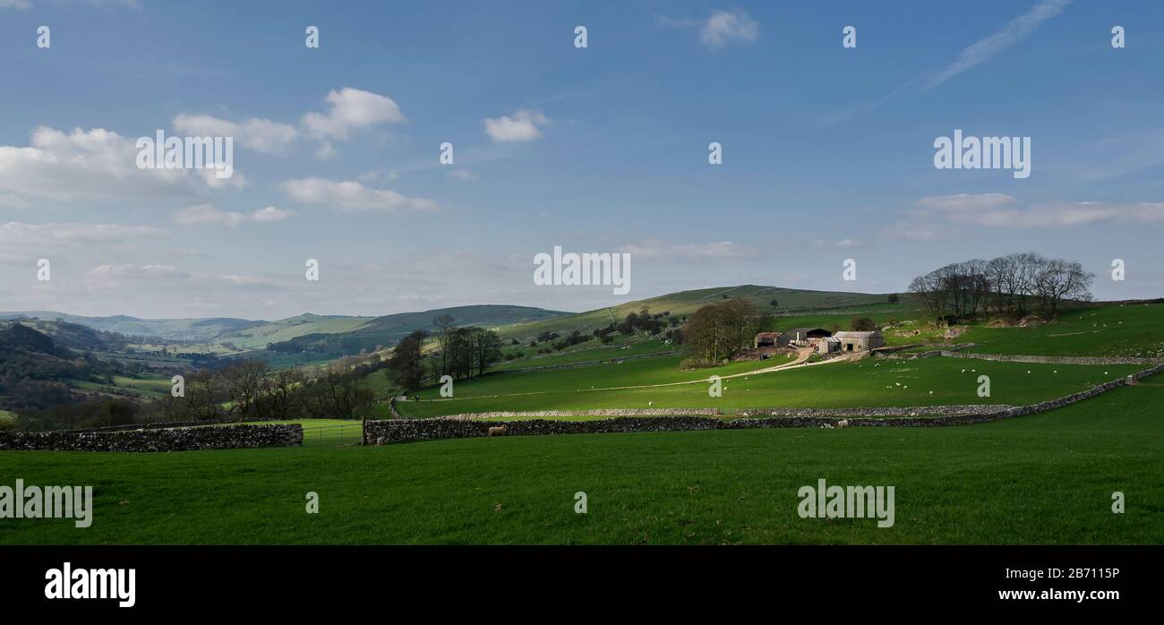 Farm with dappled light and sheep in Peak District, Derbyshire UK. Stock Photo