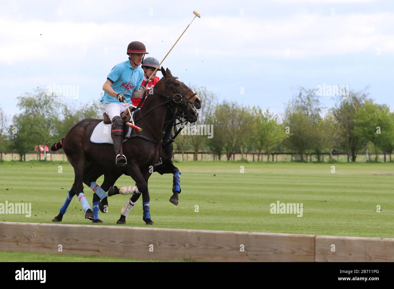 Two players battle it out for the ball during Cambridge Polo tournament Stock Photo