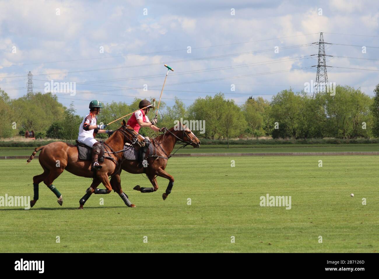 Players battle for the ball during polo tournament Stock Photo