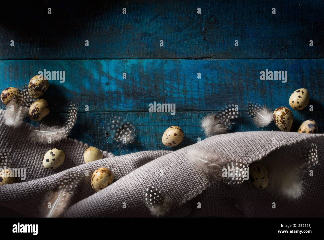 organic easter eggs and gray tablecloth on blue wooden background Stock Photo