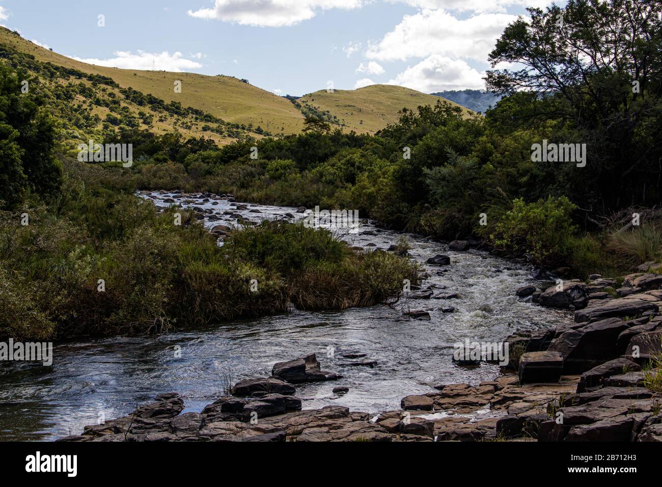 The Komati River flowing through the valley, hills in the background Stock Photo