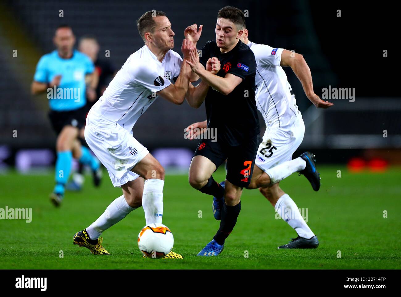 Manchester United's Daniel James (centre) ans LASK Linz's Christian Ramsebner (left) battle for the ball during the UEFA Europa League round of 16 first leg match at Linzer Stadion, Linz. Stock Photo