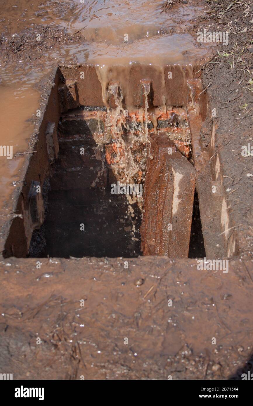 Broken storm drain. Dirty water and garbage get into the gutter. Environmental pollution. Stock Photo