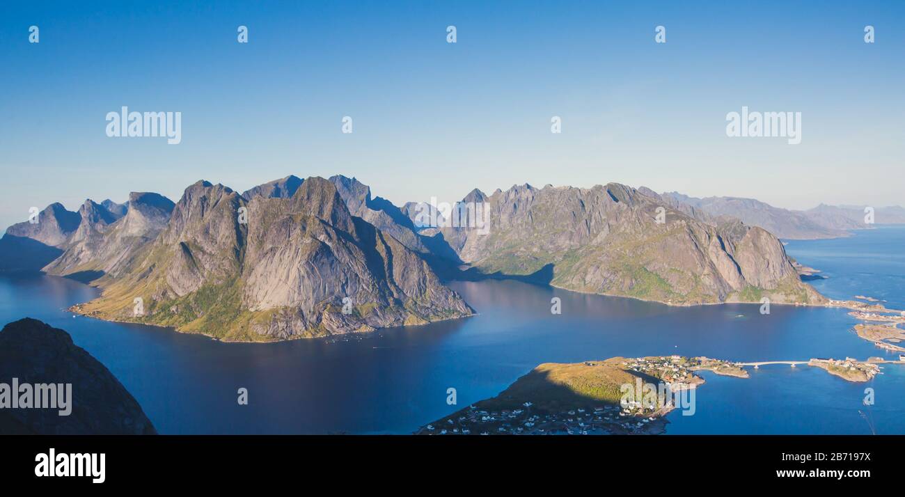 Beautiful norwegian landscape with famous top peak Reinbringen, Lofoten Islands, with a group of hikers tourists, and with a view on famous fishing vi Stock Photo