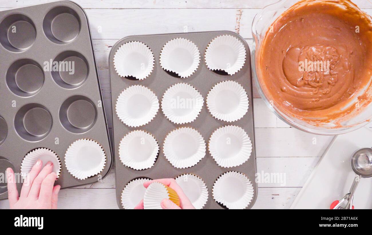 Flat lay. Cupcake pan lined with foil cupcake cups to bake chocolate raspberry cupcakes Stock