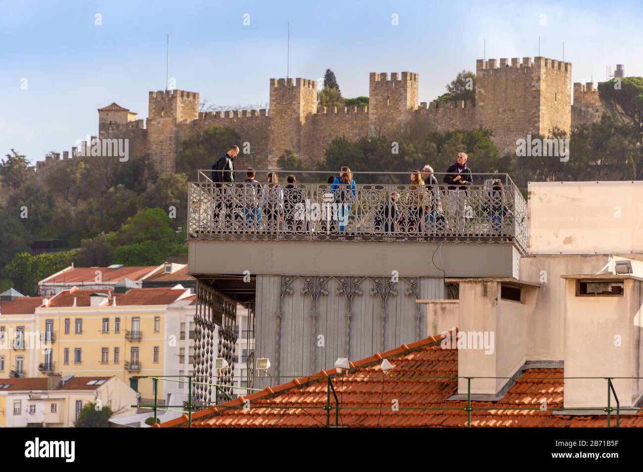 Lisbon, Portugal - 2 March 2020: Tourists lokking at the view from Elevador de Santa Justa. Lisbon Sao Jorge castle in the background. Stock Photo