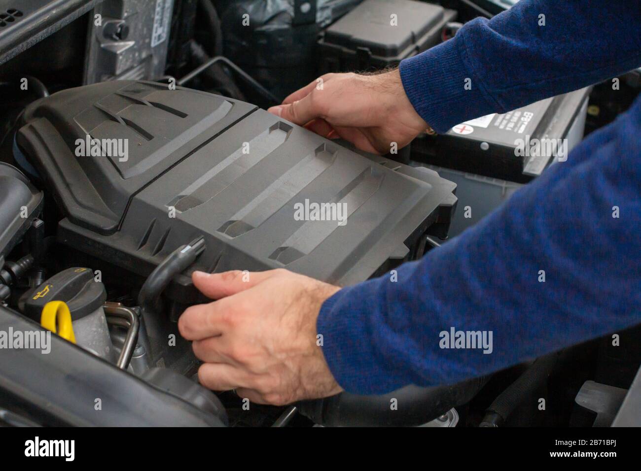 Closeup of mechanic hands checking motor under the hood in the broken car. Repairing of the vehicle concept. Automobile service Stock Photo