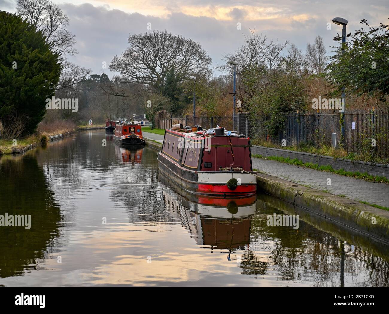 Narrowboats moored along the canal in Ellesmere Shropshire UK on a cold, calm and still winters morning. Stock Photo