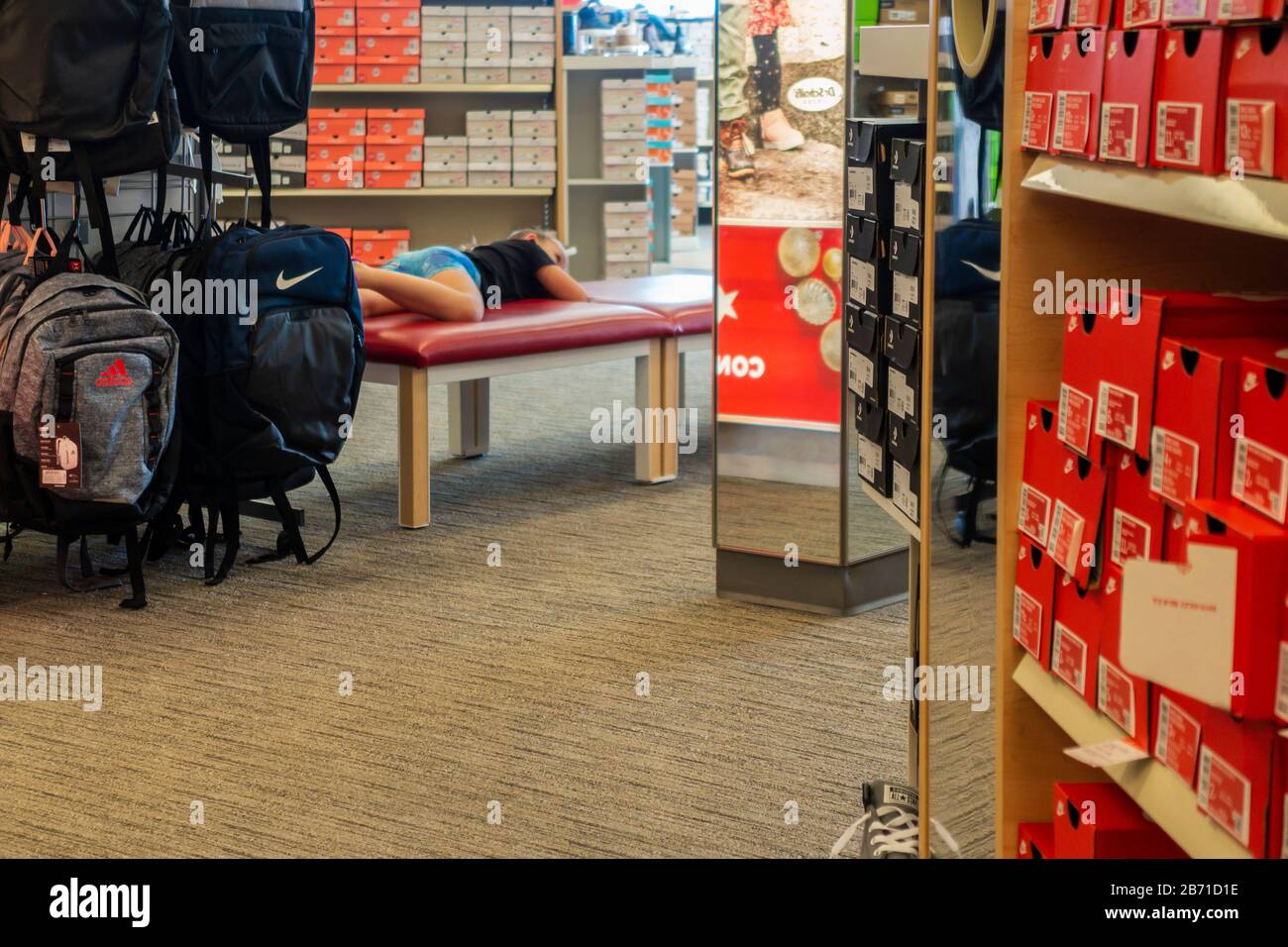 Famous Footwear interior showing a rack of Nike and Adidas backpacks and aisles of boxed shoes. USA Stock Photo