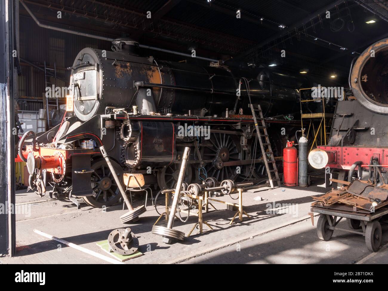Steam locomotives being repaired within the engine shed of the NYMR at Grosmont, North Yorkshire, England, UK Stock Photo