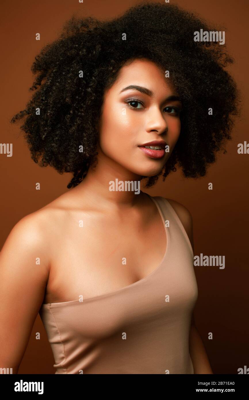 pretty young african american woman with curly hair posing cheerful ...