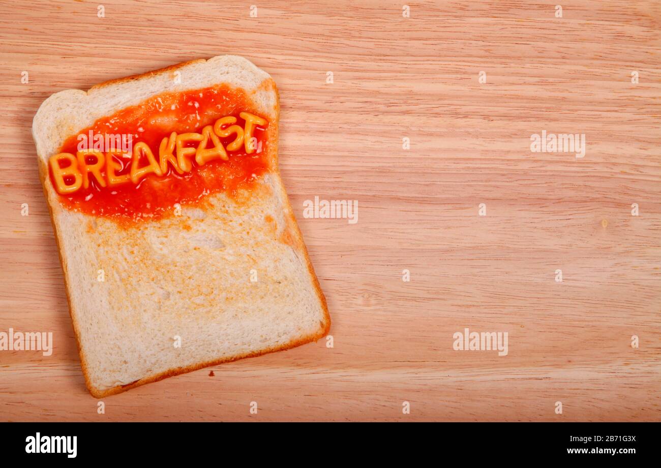 The word breakfast spelled out on a slice of toast with alphabet
