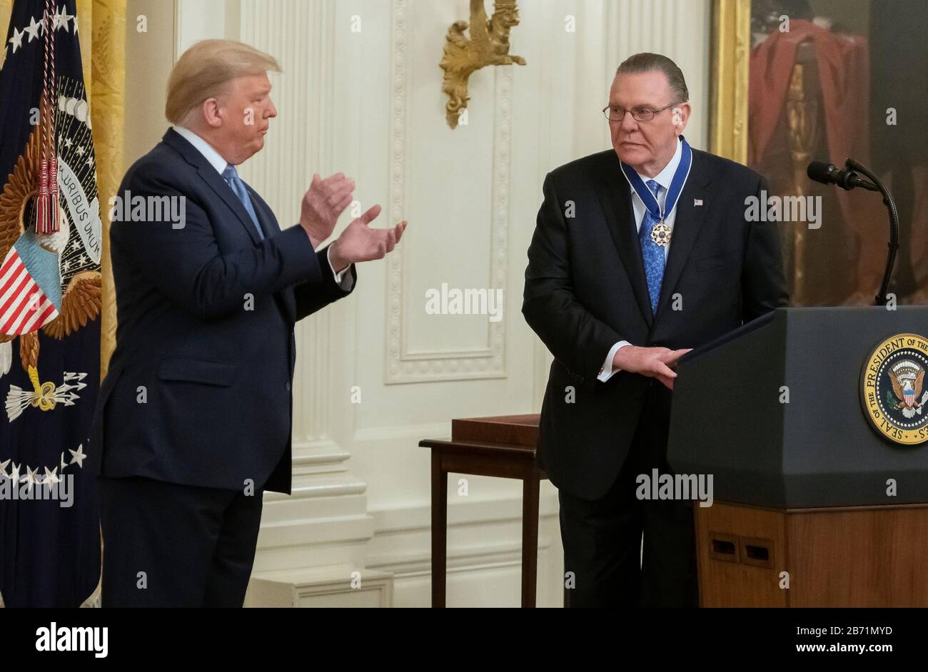 United States President Donald J. Trump, left, applauds after presents