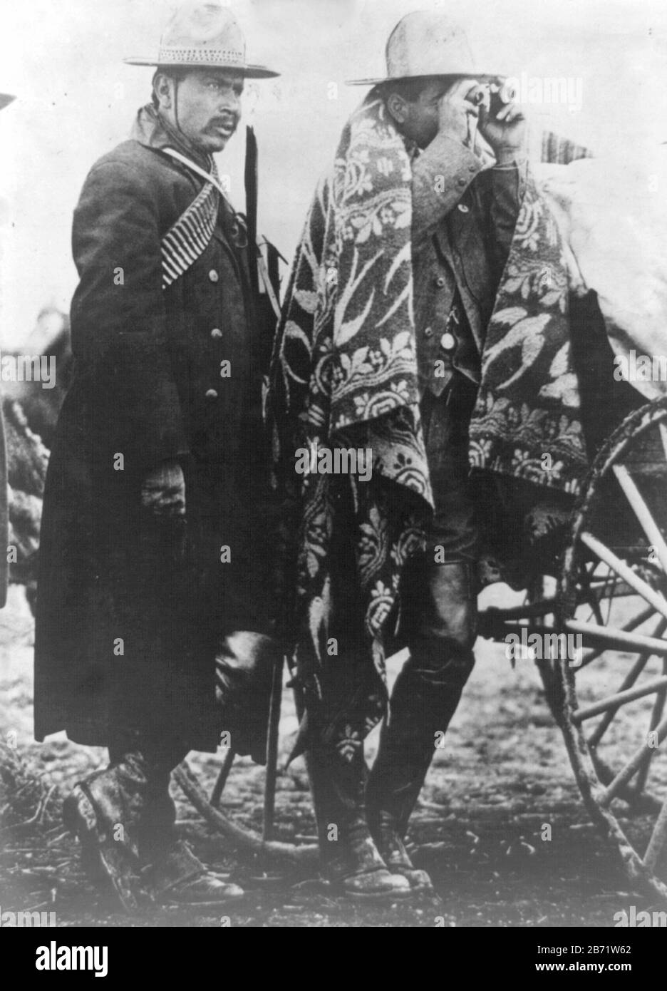 Mexican commanding general looks like in the thick of battle, General Villa Photograph of two soldiers. On the right is Francisco 'Pancho' Villa looking through binoculars. Stock Photo